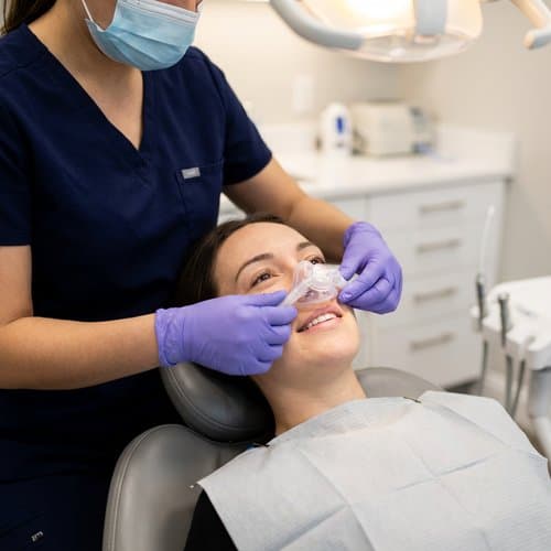 Patient relaxed in the chair with a nitrous oxide nasal mask—comfortable sedation dentistry